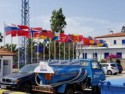 Flags from lots of countries next to a refueling truck